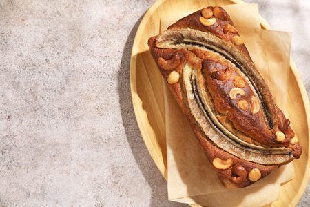 Homemade banana bread with nuts on grey table, top view. Space for textの写真素材