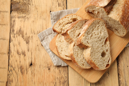 Pieces of fresh bread on wooden table, top view. Space for text