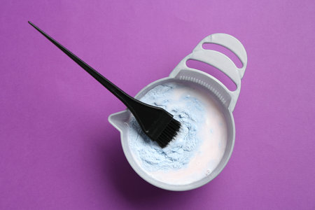 Mixing hair bleaching powder and developer on purple background, top viewの写真素材