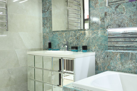 Stylish bathroom with bathtub and vanity near tiled wall. Interior designの写真素材