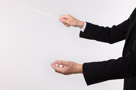 Conductor with baton on light gray background, closeup. Space for textの写真素材