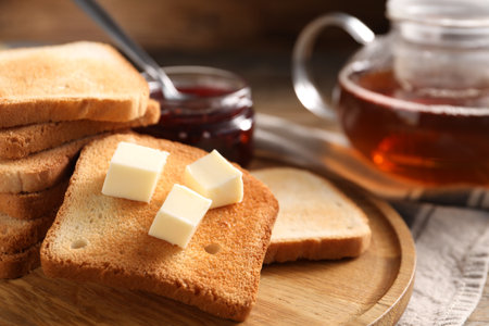 Slices of tasty toasted bread with butter on table, closeupの写真素材