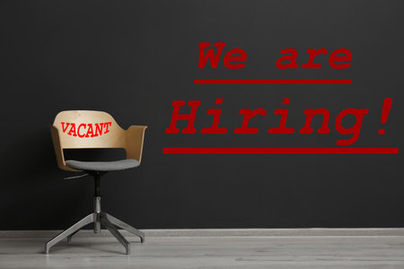 We are hiring. Empty office chair with word Vacant in room. Recruitment conceptの写真素材