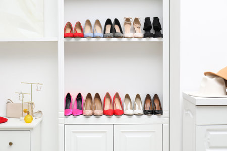Shoe storage. Shelving unit with different high heeled shoes and accessories indoorsの写真素材