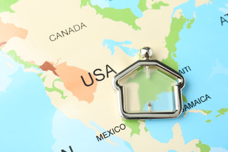 Metal house figure on world map, closeupの写真素材