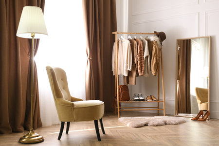 Comfortable armchair and rack near window with stylish curtains in room. Interior designの写真素材