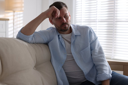 Depressed man on sofa at home. mental health problemの写真素材