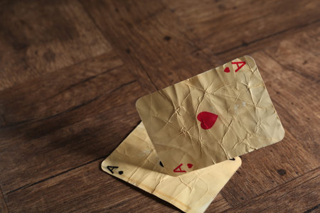 Old vintage playing cards on wooden table, closeup. Space for text