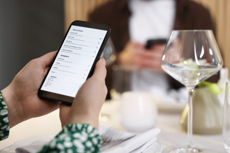 Couple choosing dishes from digital menu at restaurant, closeup