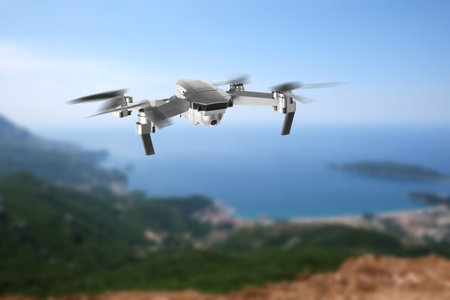 Drone with camera flying in mountains. Unmanned aerial vehicle for surveillanceの写真素材