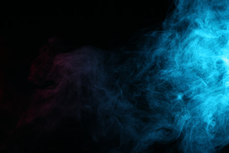 Beautiful smoke in blue light on dark background. Space for textの写真素材