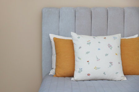Soft decorative pillows on bed in bedroomの写真素材