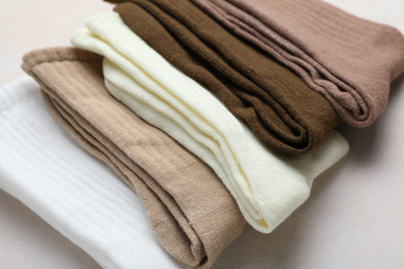 Different soft socks on light beige background, closeup