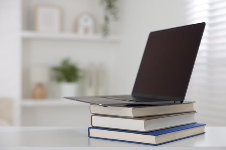 Different book and laptop on white desk indoors. Space for textの写真素材