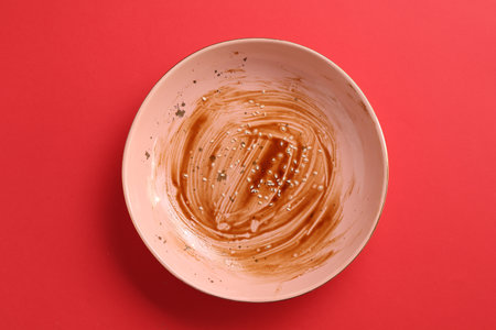 One dirty plate on red background, top viewの写真素材