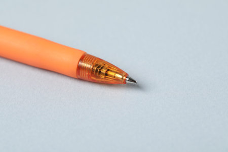 One ballpoint pen on grey background, macro view. Space for text