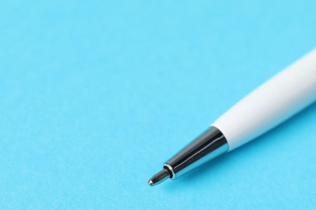 One ballpoint pen on light blue background, macro view. Space for textの写真素材