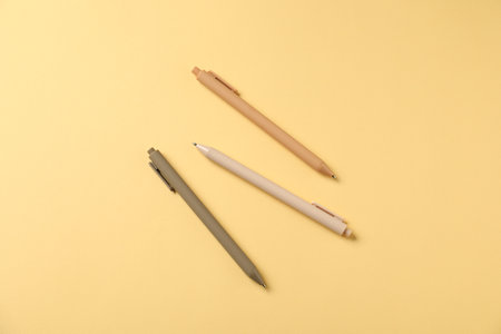 Stylish pens on yellow background, flat layの写真素材