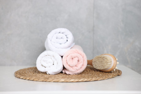 Clean towels and brush on white table indoors