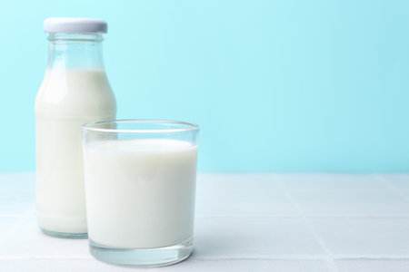 Fresh milk on white table against light blue background. Space for textの写真素材