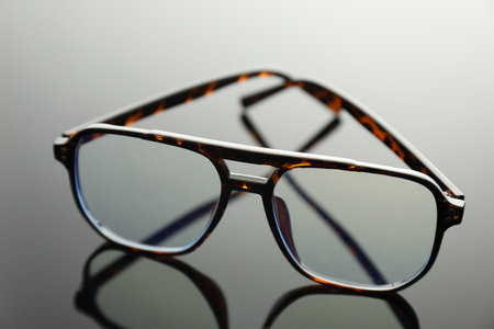 Stylish glasses on grey mirror surface, closeupの写真素材