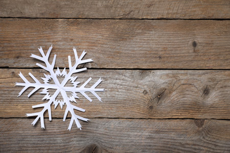 One paper snowflake on wooden background, top view. Space for textの写真素材