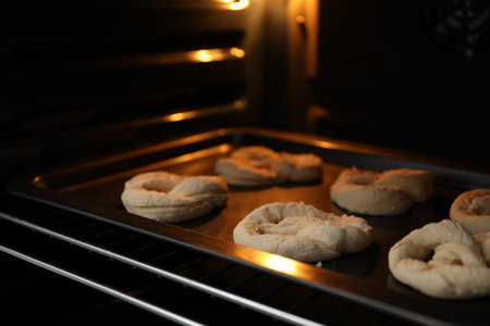Baking dish with uncooked pretzels in oven, closeup