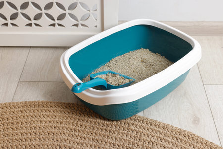Cat litter box with filler and scoop on floor indoorsの写真素材