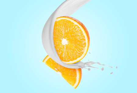 Milk splash and orange in air on light blue gradient backgroundの写真素材