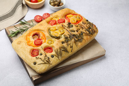 Delicious focaccia with flowers made of vegetables on light gray tableの写真素材
