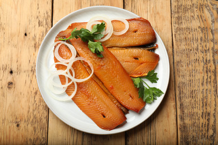 Smoked herrings, parsley and onion on wooden table, top view