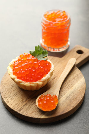 Tasty canape with red caviar, spoon and parsley on gray table, closeupの写真素材