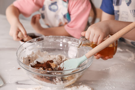 Cooking recipe. Cute children making dough for cookies at table in kitchen, closeupの写真素材
