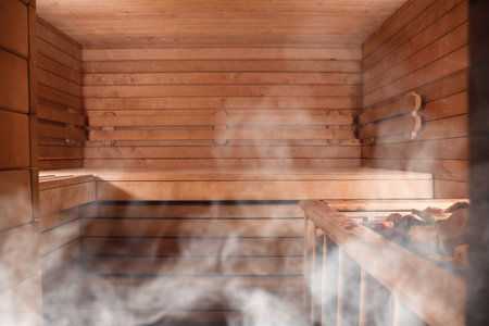 Wooden sauna with bench and hot stones in steamの写真素材