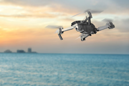 Drone with camera flying over sea. Unmanned aerial vehicle for surveillance