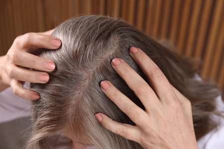 Senior woman with healthy hair roots on blurred background, closeupの写真素材