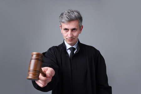 Portrait of judge with mallet on gray backgroundの写真素材