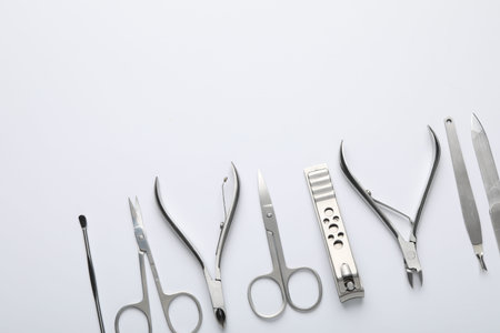 Set of different manicure tools on white background, flat lay. Space for text