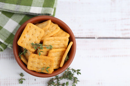 Tasty salty crackers with thyme on white wooden table, flat lay. Space for textの写真素材