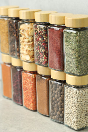 Many different aromatic spices in jars on table indoors, closeupの写真素材