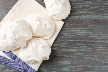 Delicious homemade meringue cookies on wooden table, top view. Space for textの写真素材