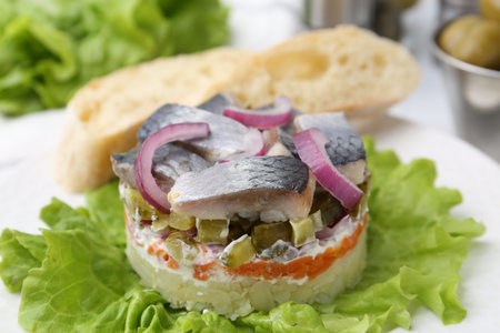 Delicious salad with herring, vegetables and bread on table, closeup