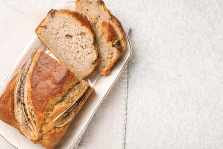 Cut banana bread on light grey table, top view. Space for text
