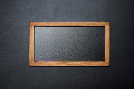 Blank small blackboard on black textured background, top viewの写真素材