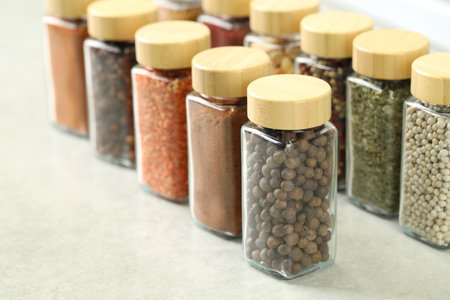 Many different aromatic spices in jars on light gray table indoors, closeupの写真素材