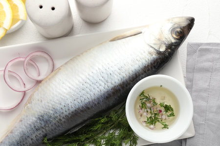 Salted herring and spices on white table, flat layの写真素材