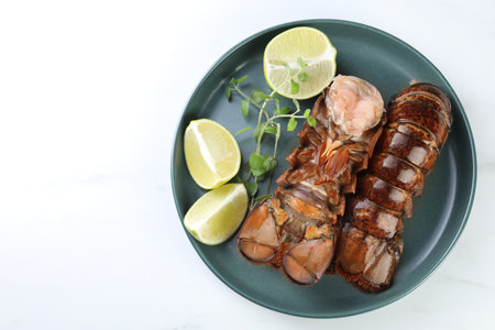 Raw lobster tails, lime and microgreens on white marble table, top view. Space for textの写真素材