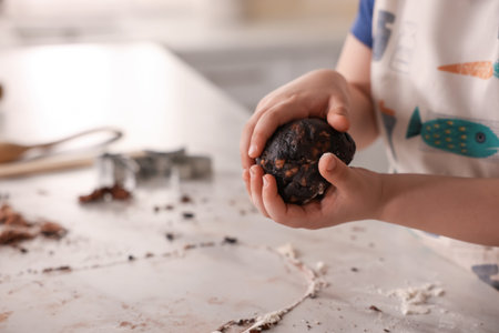 Cooking recipe. Little boy making dough for cookies at table in kitchen, closeup. Space for textの写真素材