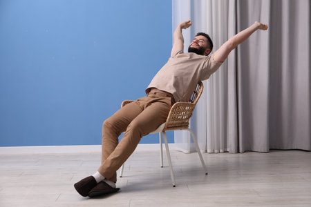 Handsome man relaxing on chair at homeの写真素材