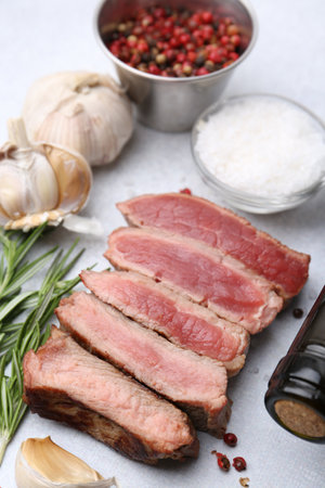 Delicious sliced beef tenderloin with different degrees of doneness and spices on light table, closeupの写真素材